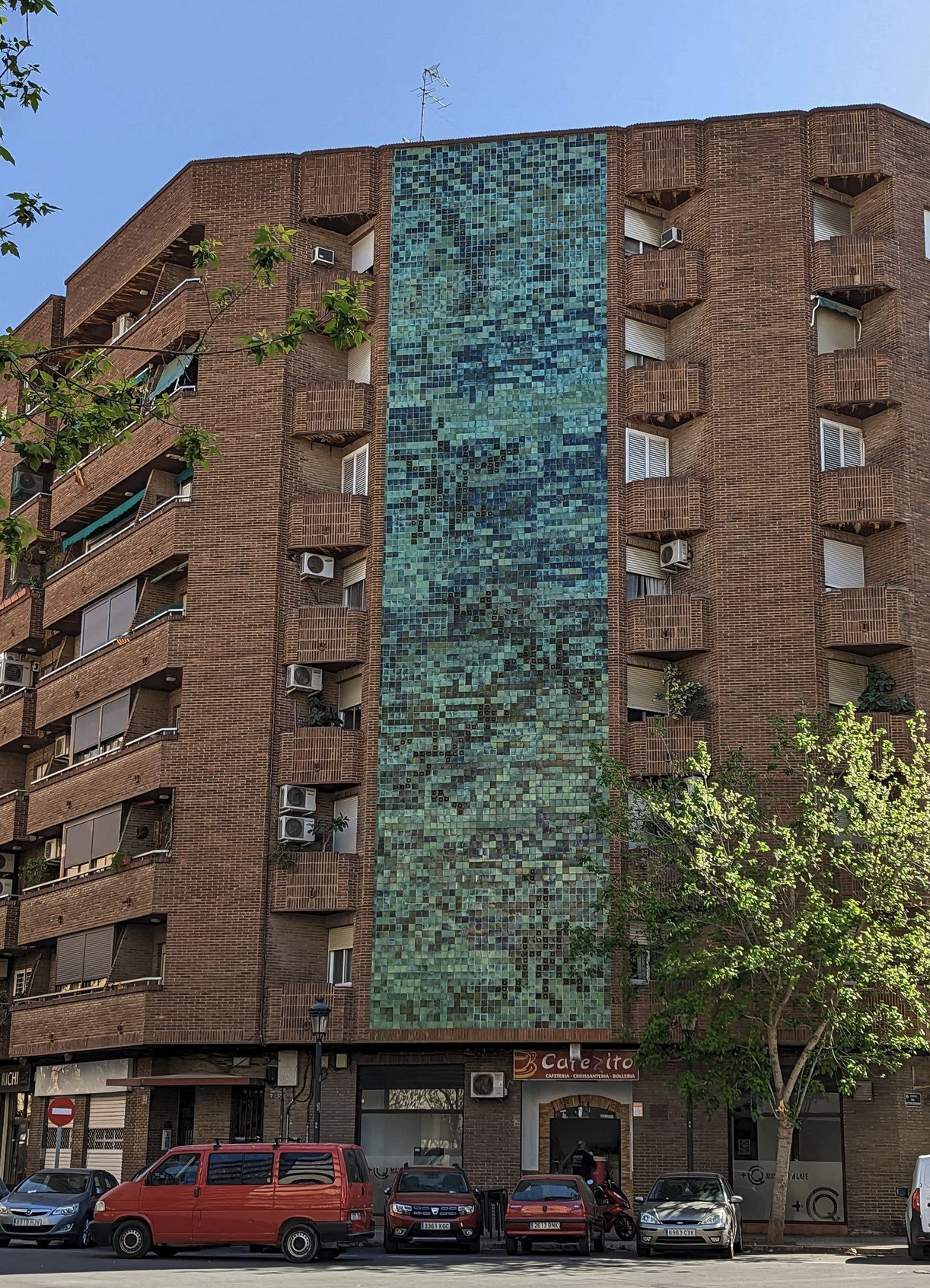 A seven story building that on the front side has from top to bottom a square title pattern similar to a Github commit history display.