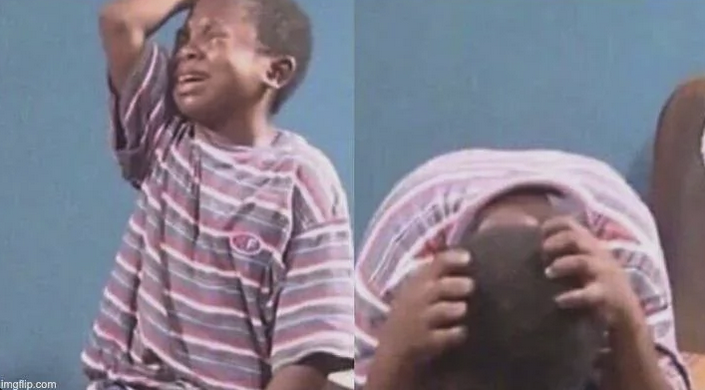 A child crying and putting his head down on a desk.