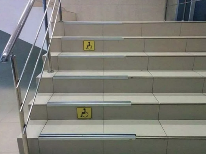 Picture of wide set of stairs and on the left there's a 3 foot wide part of the stars with a little floor grip tape on every step and yellow handicaps stickers every other step.... yes, on the stairs. This is next to the handrail though.