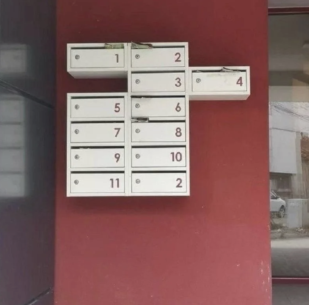 Mailboxes on a wall but one row is off centered.