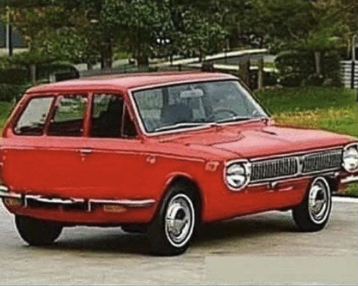 A red car but the wheels and side make it look like the car was constructed by a crazy person.